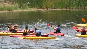 Campers kayak down the river. 