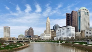 A cityscape with a blue sky, skyscrapers and a river