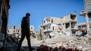 a man looks out over a pile of rubble and landscape of crumbled buildings