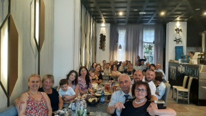 a large group of people seated around a table in a restaurant.