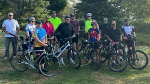 a group of people standing outdoors with their bicycles