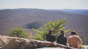 A photo of three friends gazing at the mountains, taken from behind.