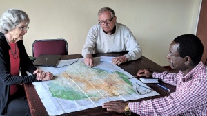 Mabasa Chichaya discusses the perils of Church members with Vic and Bev Kubik over a map of Zimbabwe.