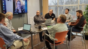 Our Web development team, joined by home office management, discussing how to best cover the many tasks Tom Disher was responsible for until a replacement for him can be found. (From left to right: Chris Stewart, Richard Kennebeck, Melanie May via Skype)