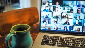 Photo of coffee cup and a zoom call on laptop.