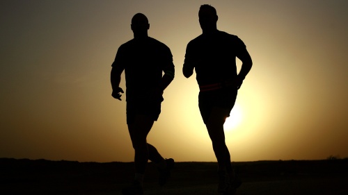silhouettes of two men running