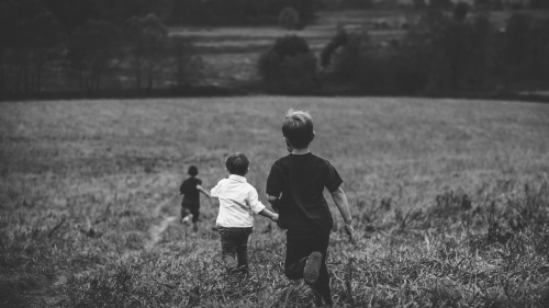 Three boys running in a field