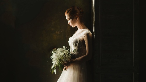 a bride standing alone and looking at the ground