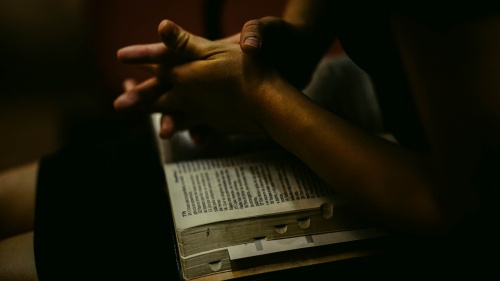 A person with an open Bible on their lap.