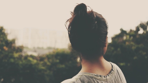 a woman's head, turned towards the landscape with trees