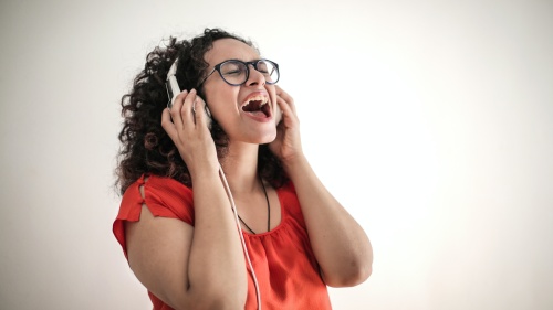 a woman singing and wearing headphones