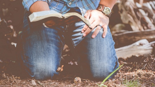 Man kneeling with Bible