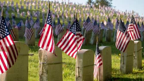 American flags attached to gravestones.