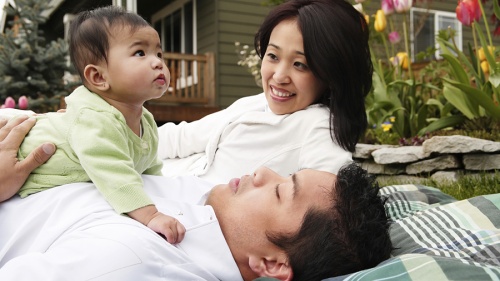 A husband and wife holding their baby.