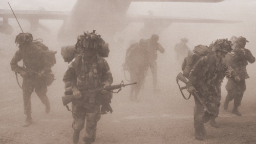 Soldiers coming out of an airplane.