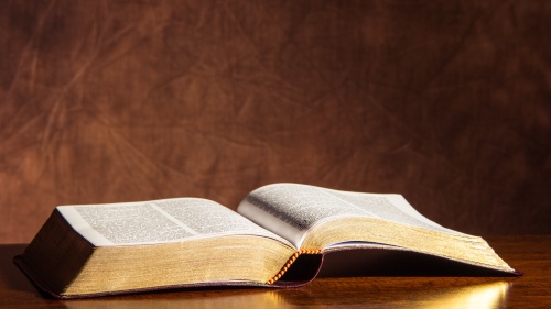 An open Bible laying on a table.