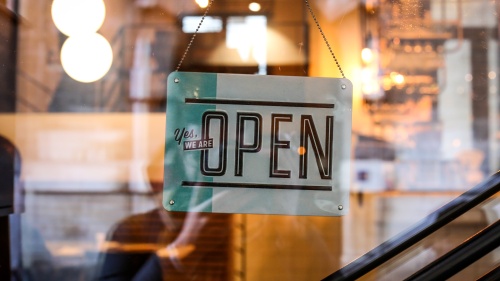 An open for business sign on a store window.