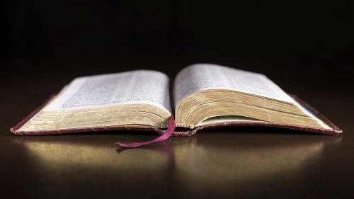 An open Bible laying on a table.