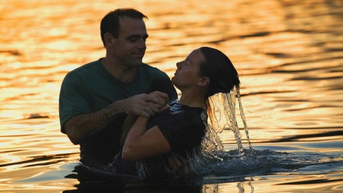 A scene of a person getting fully submersed in a water baptism.