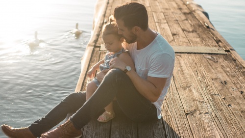 A dad sitting with his daughter.