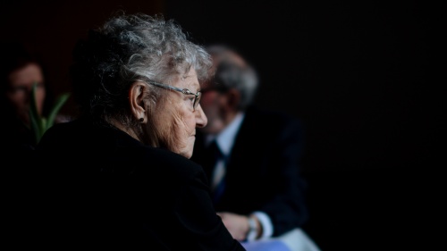 A elderly woman sitting by herself. 