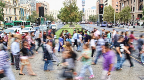 A blur of crowded city sidewalk of people walking.