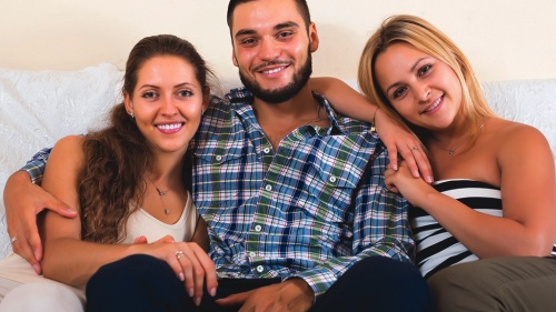 A man sitting with two women.