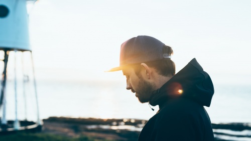 A man look down with sunbeam behind him.