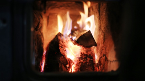 A fire burning inside a wood stove.