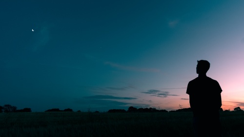 A young man looking up at the night sky.