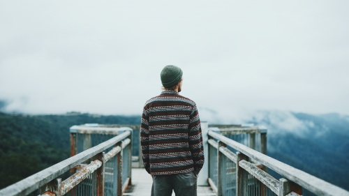 A man walking on a wooden path.