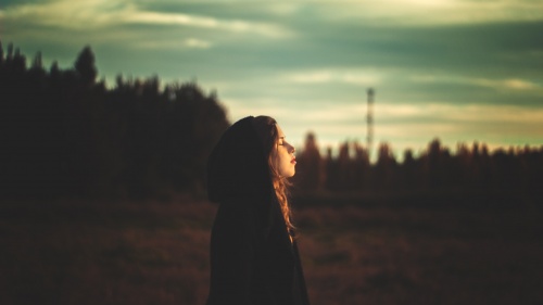 A young woman looking up at the sky.