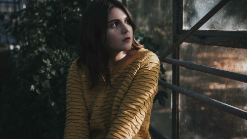 A young woman looking out a window.