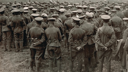 An old WWI photograph showing a church service in the field with soldiers watching a priest.