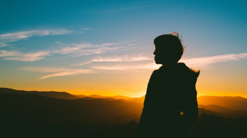 A silhouette of person as the sun is setting.