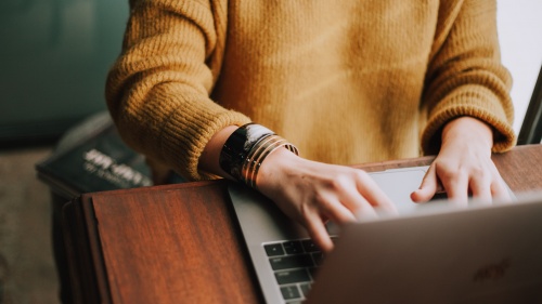 A woman typing on a laptop.