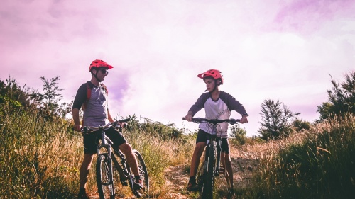 A dad and son riding mountain bikes.