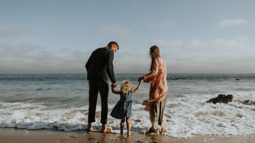 A family wading in the waves of the ocean.