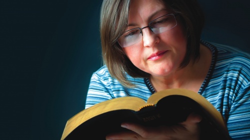 A woman reading a Bible.