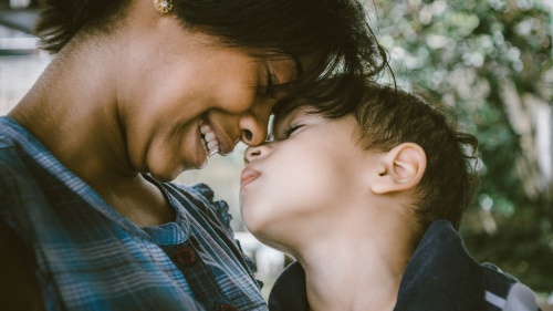 A mother and child touching foreheads. 