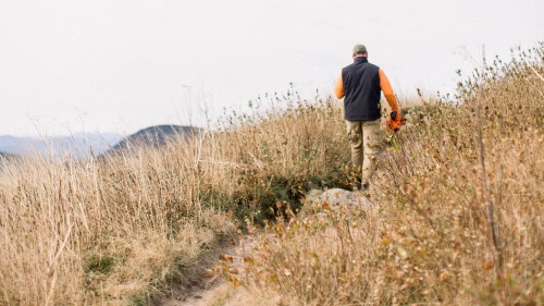 A man walking on a dirt trail. 