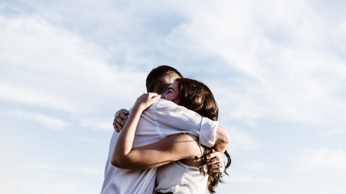 Man and woman reuniting and hugging each other.