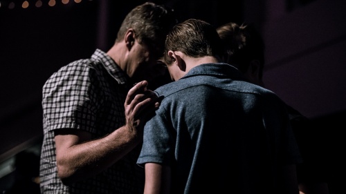 Two men praying together.