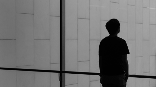 A person looking past a large glass window.