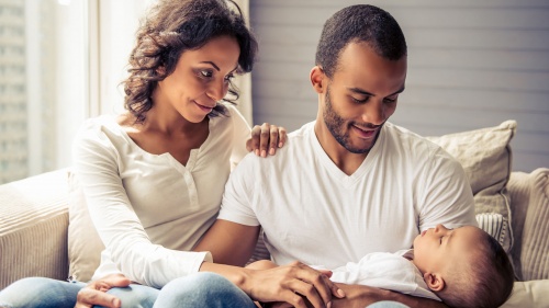 A man and woman holding a baby.