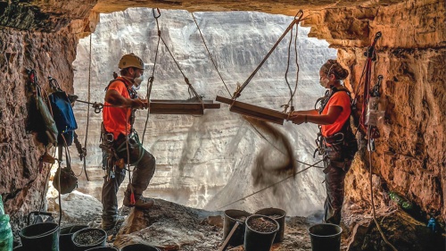 Israeli archeologists Hagay Hamer and Oriah Amichai sift dirt at a cave in the Judean Desert where addtional ancient scroll fragments were found.