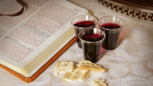 An open Bible with Passover wine an pieces of unleavened bread.