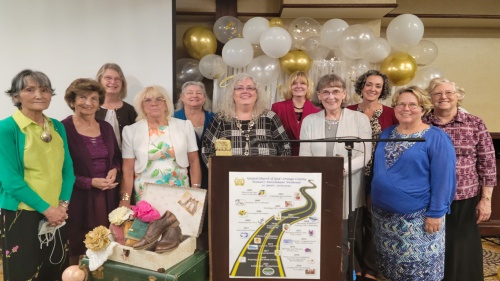 a group of women gathered behind a poster and vintage decorations