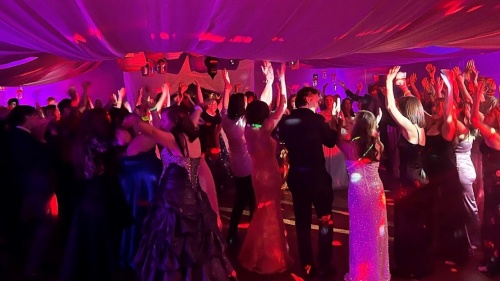 A group of teenagers in formal attire at a dance