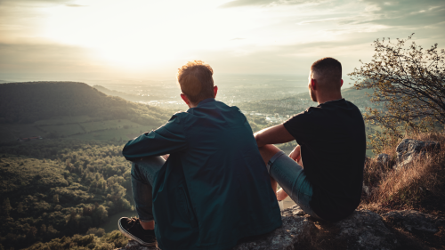 Two people sitting outdoors looking over a landscape